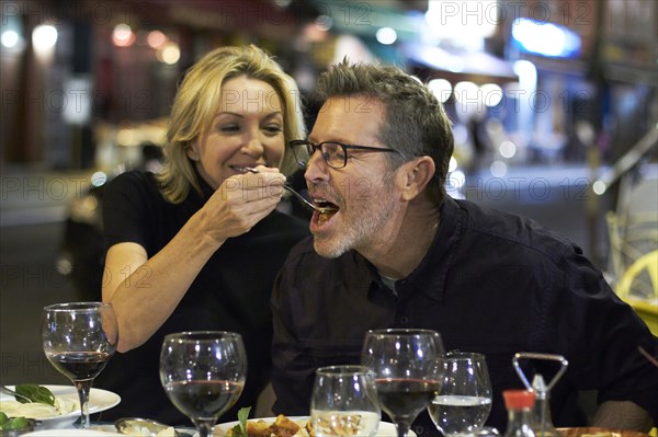 Caucasian couple eating at urban cafe