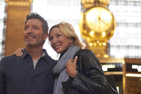 Caucasian couple hugging in Grand Central Station