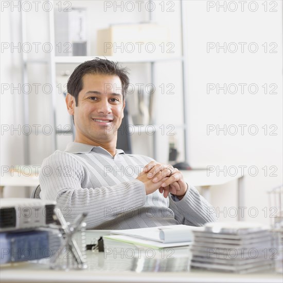 Hispanic man sitting at desk