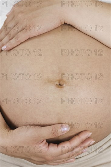 Close up of Chinese woman's pregnant stomach