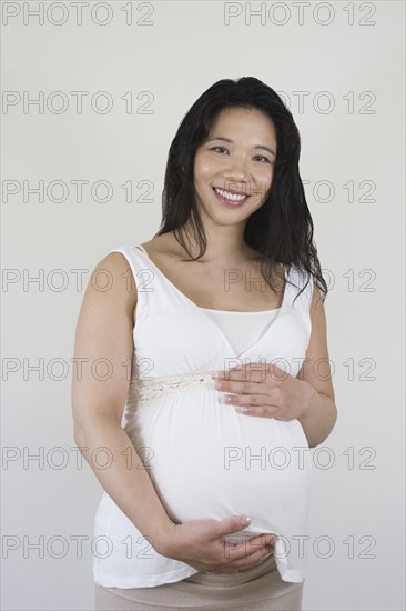 Pregnant Chinese woman holding stomach