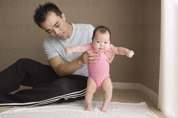 Chinese father helping daughter to learn to walk