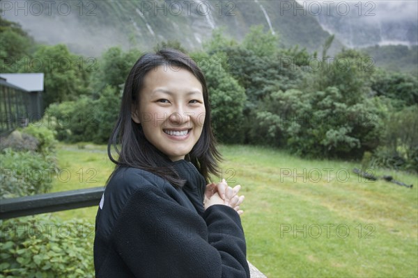 Chinese woman standing on balcony in remote area