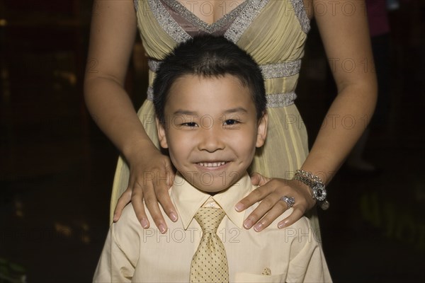 Chinese boy standing with mother