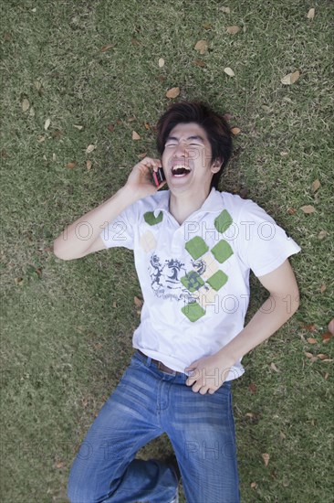 Chinese man laughing and using cell phone