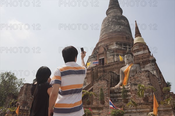 Asian couple photographing temple