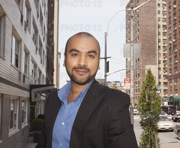 Mixed race businessman standing on urban street