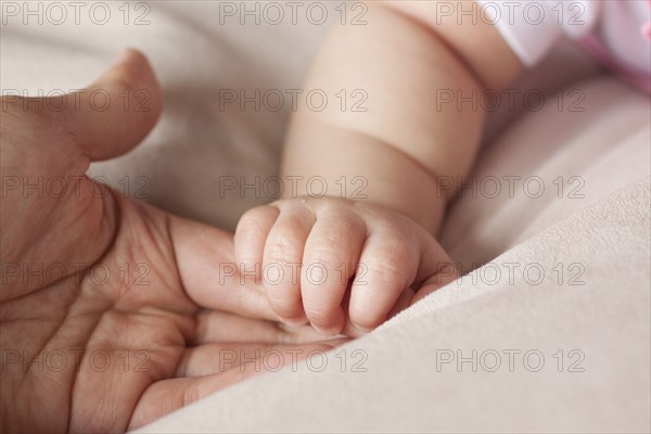 Chinese father holding baby's hand