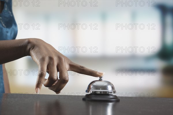 Black woman ringing reception desk bell