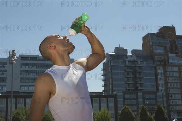 Mixed race athlete drinking water