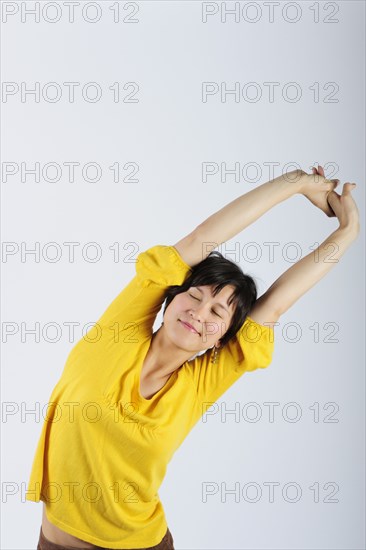 Filipino woman stretching arms overhead