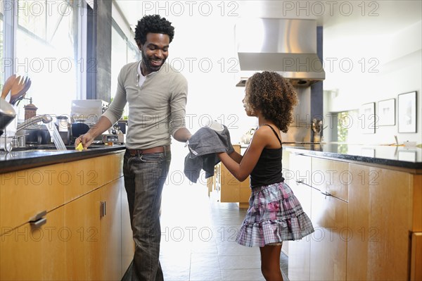 Father and daughter washing dishes