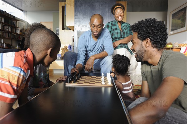 Black family watching chess game