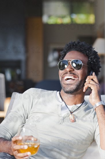 Black man talking on cell phone and drinking