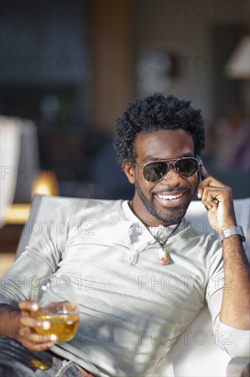 Black man talking on cell phone and drinking