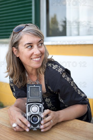 Caucasian woman holding old-fashioned camera