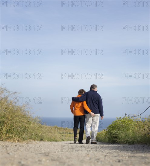 Caucasian couple walking on beach