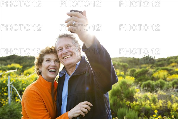 Caucasian couple taking picture outdoors