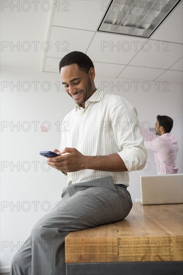 Businessman using cell phone in office