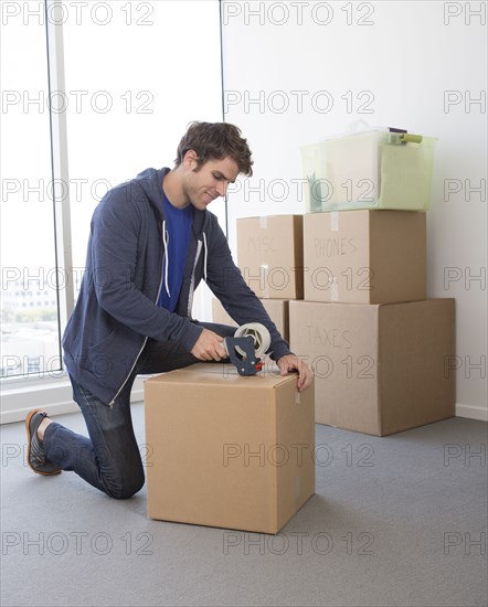 Caucasian man packing cardboard boxes