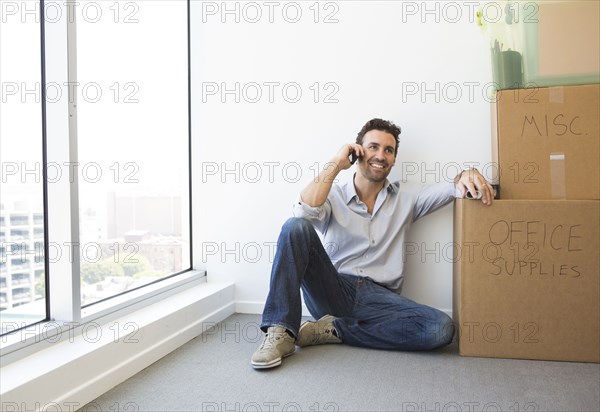 Hispanic businessman on cell phone in new office