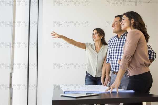 Business people examining blueprints in office