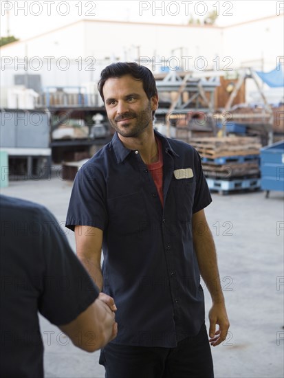 Workers shaking hands in warehouse