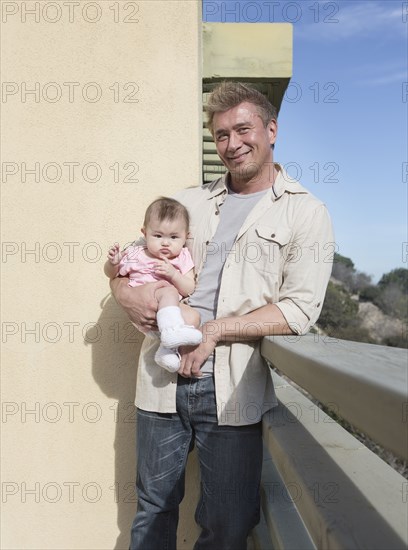 Father holding baby girl outdoors