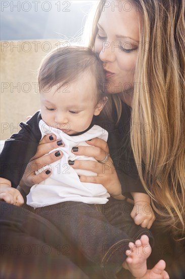 Mother kissing baby boy outdoors