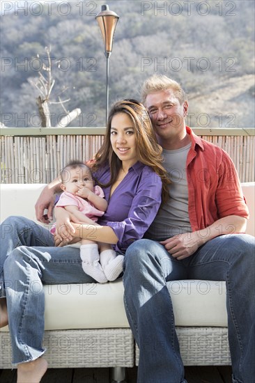 Family smiling on patio sofa