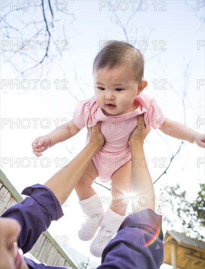 Mother playing with baby girl outdoors