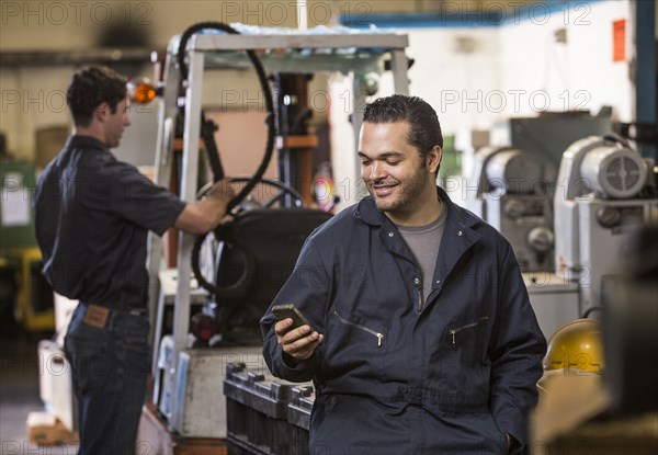 Worker using cell phone in warehouse