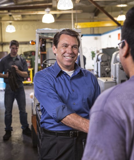 Manager and worker shaking hands in warehouse