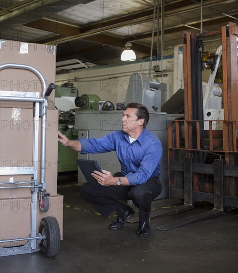 Caucasian businessman examining boxes in warehouse