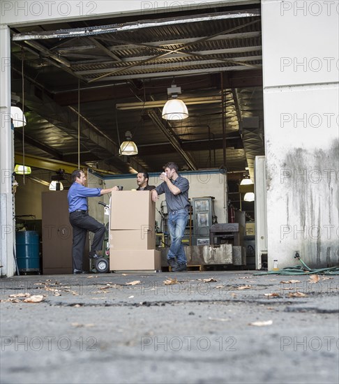 Workers enjoying coffee break at warehouse loading dock