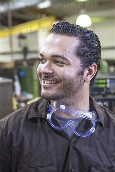 Hispanic worker smiling in warehouse