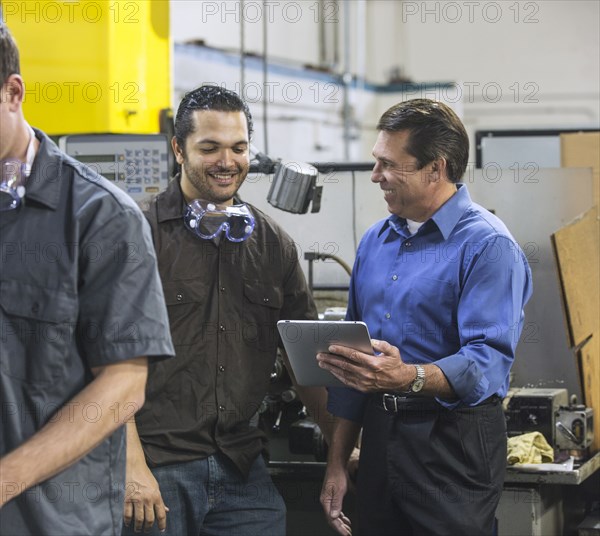 Worker and manager using digital tablet in warehouse