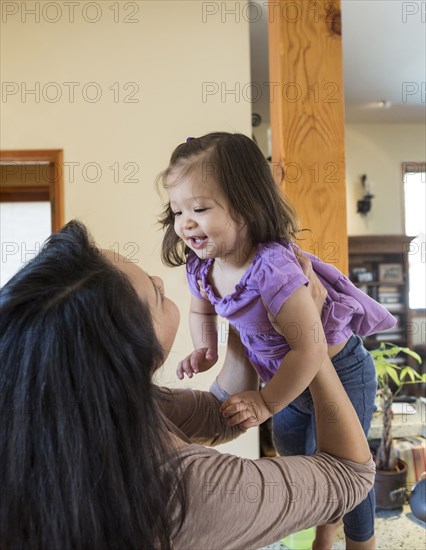 Mother holding daughter in kitchen