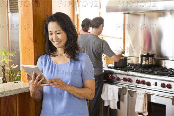 Woman using digital tablet in kitchen