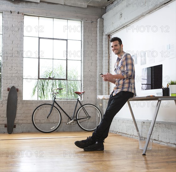 Caucasian architect using cell phone in office