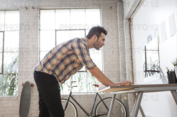 Caucasian architect reading blueprints in office