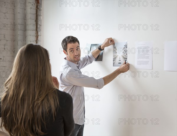 Caucasian architects examining photos in office