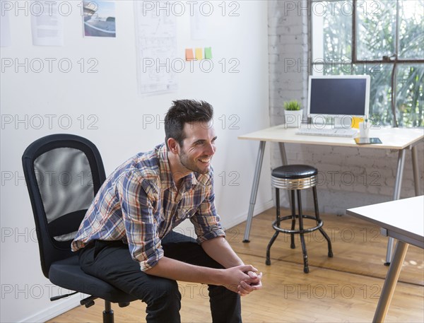 Caucasian architect smiling in office