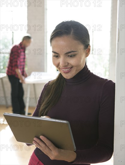 Mixed race architect using digital tablet in office