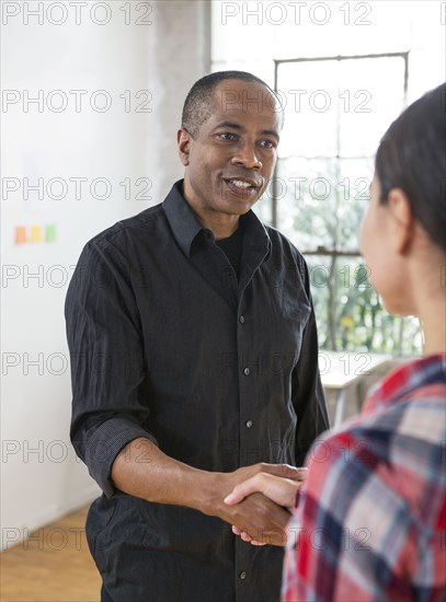 Architects shaking hands in office