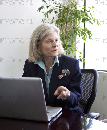 Caucasian businesswoman talking at desk