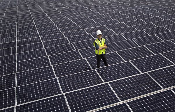 Caucasian technician smiling on solar panels