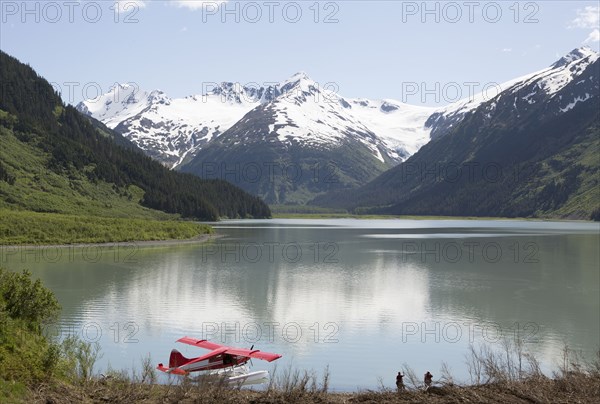 Seaplane docked in still lake in mountain landscape