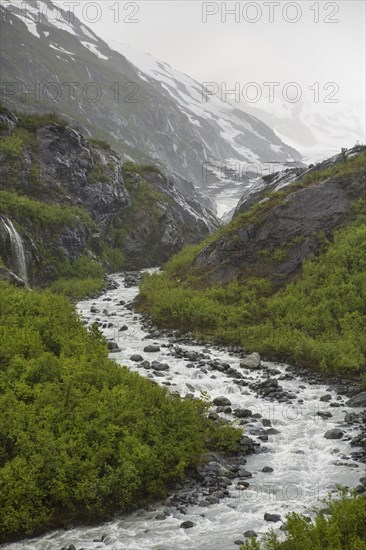 Rocky river flowing through snow covered mountains