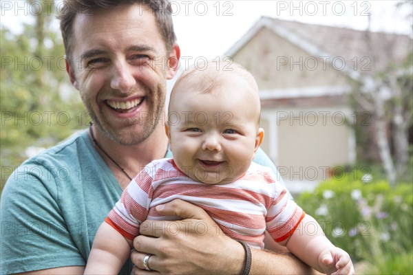 Caucasian father holding baby outdoors
